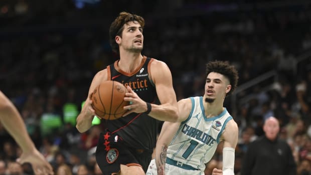 Washington Wizards forward Deni Avdija (8) makes aa move to the basket y Charlotte Hornets guard LaMelo Ball (1) during the first half at Capital One Arena.